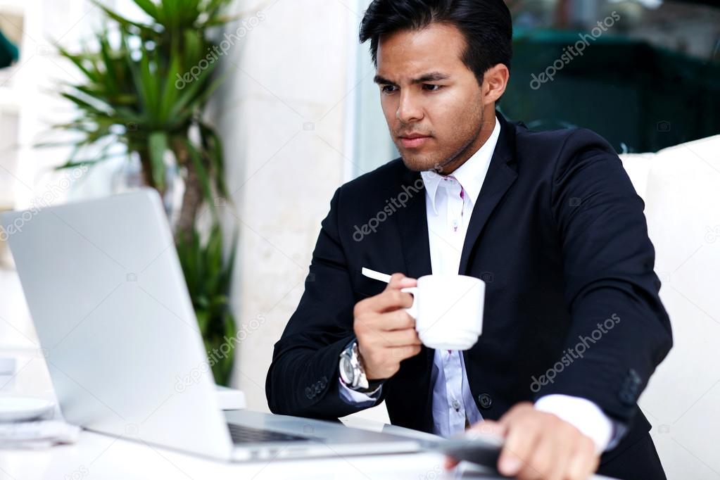 Businessman reading latest news on laptop