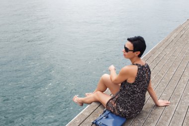 Attractive woman sitting on a wooden pier