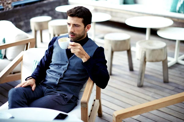 Businessman in suit enjoying a cup of coffee — Stok fotoğraf