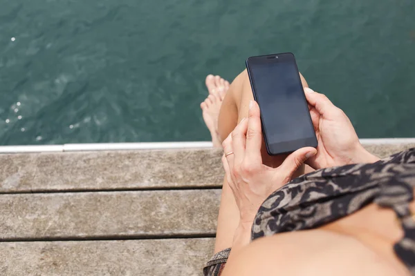 Vista posterior de la mujer con el teléfono inteligente — Foto de Stock