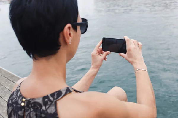 Woman taking picture of the sea — ストック写真