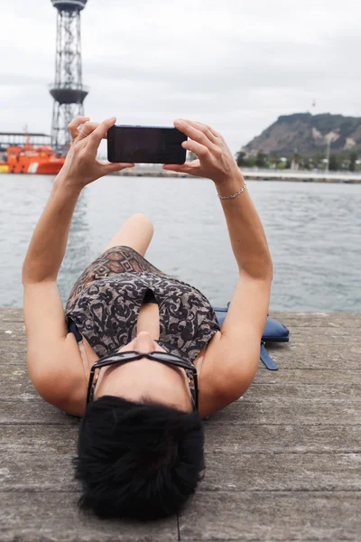 Mujer morena sosteniendo teléfono celular — Foto de Stock