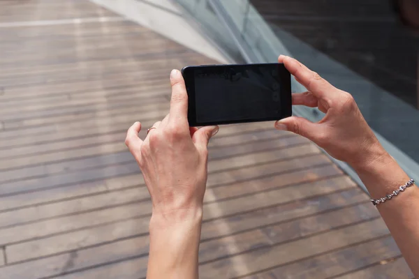 Manos femeninas sosteniendo teléfono móvil — Foto de Stock