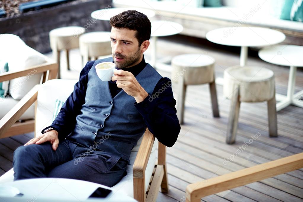 Businessman in suit enjoying a cup of coffee