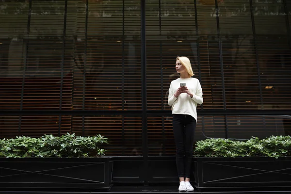 Ung kvinna med mobiltelefon utanför — Stockfoto