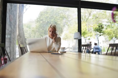 Woman having smartphone conversation in cafe