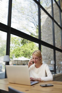Businesswoman working on net-book in modern cafe