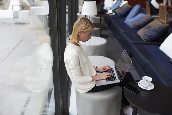 Mujer trabajando en net-book en cafetería — Foto de Stock