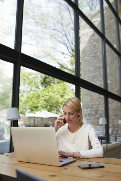 Businesswoman working on net-book in modern cafe — Stok fotoğraf