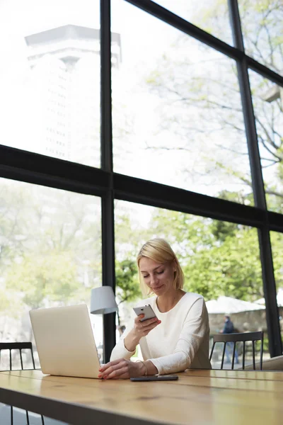 Freelancer reading text message on smartphone — Stok fotoğraf