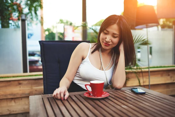 Asiatisk kvinna sitter i modernt kafé — Stockfoto