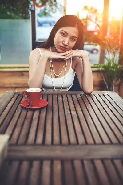 Asiatisk kvinna sitter i modernt kafé — Stockfoto