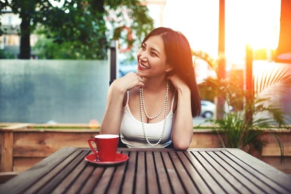 Lächelnde asiatische Frau sitzt im Café — Stockfoto