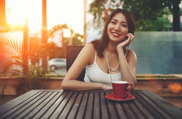 Asyalı kadın cafede oturan gülümsüyor — Stok fotoğraf