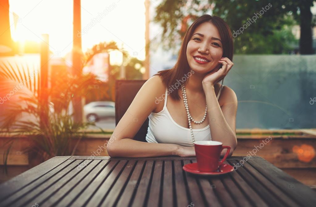 Smiling asian woman sitting in cafe