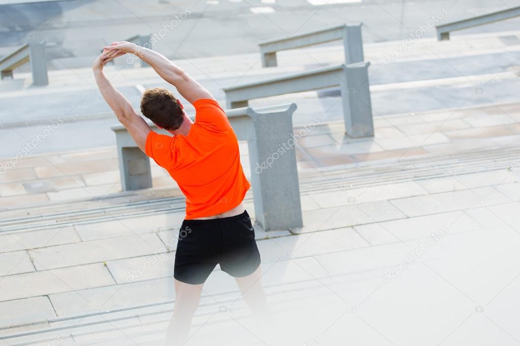 Athletic man stretching hands muscles