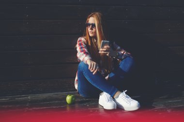 Hipster girl using her smartphone outdoors