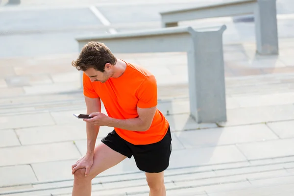 Молодой спортсмен с помощью мобильного телефона — стоковое фото