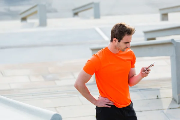 Young sportsman using mobile phone — Stock Photo, Image