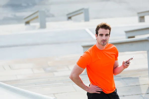 Joven deportista usando teléfono móvil — Foto de Stock