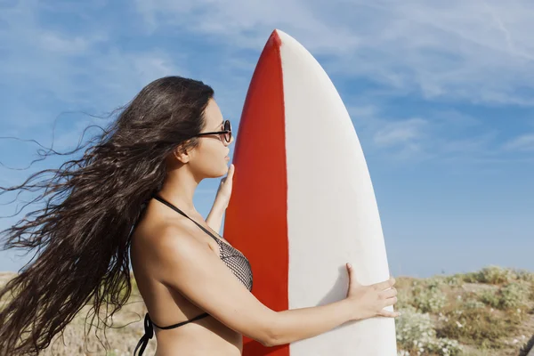 Woman posing outdoors with her surfboard — ストック写真