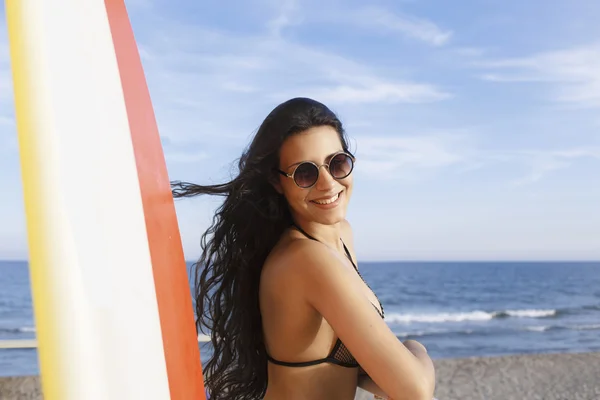 Frau steht mit Surfbrett am Strand — Stockfoto