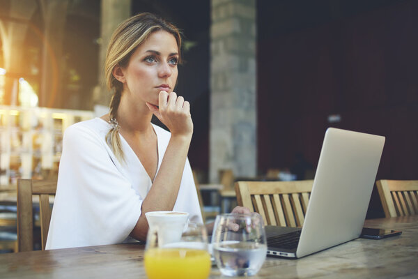Woman resting after work on laptop in cafe