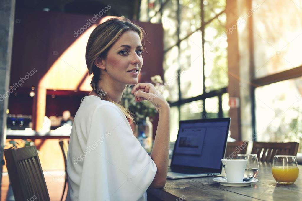Woman resting after work on laptop in cafe