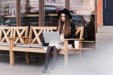Young woman working on net-book in cafe
