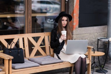 Young woman working on net-book in cafe