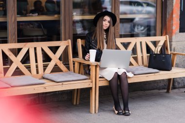 Young woman working on net-book in cafe
