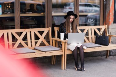 Young woman working on net-book in cafe