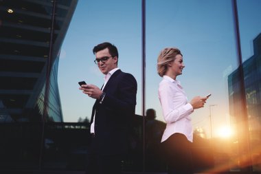 Two businesspeople using mobile phones