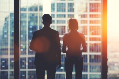 Team of business partners looking out of window