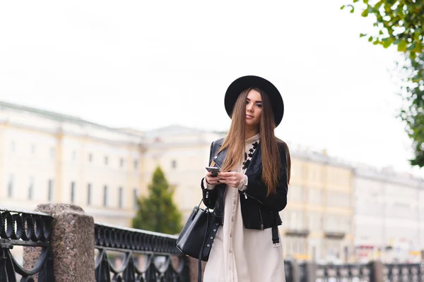 Kvinna med mobiltelefon promenader på gatan — Stockfoto