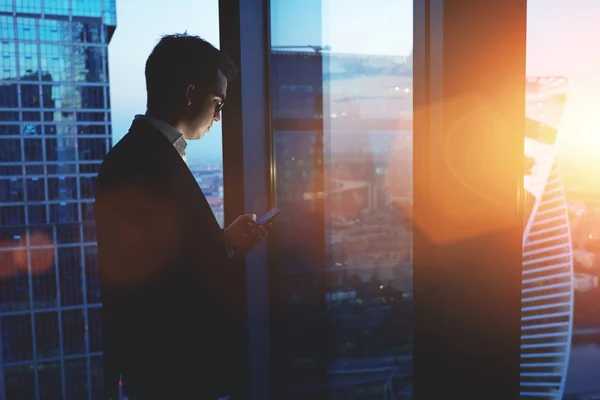 Empresário usando smartphone ao pôr do sol — Fotografia de Stock