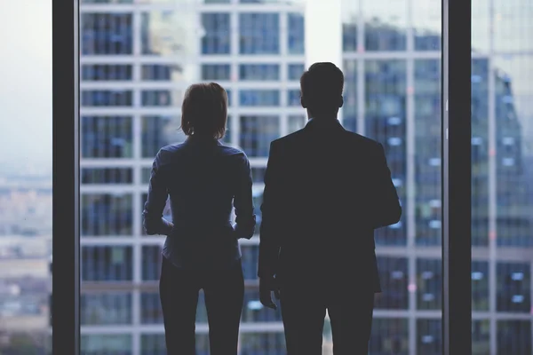 Team of business partners looking out of window — Stock Photo, Image