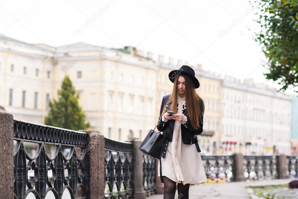 Woman with mobile phone walking on the street