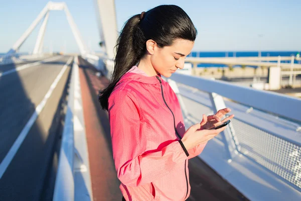 Sportswoman using smart phone — Zdjęcie stockowe