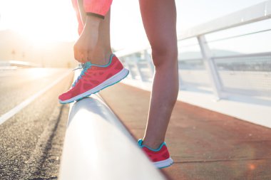 Woman tying the lace on her running shoes