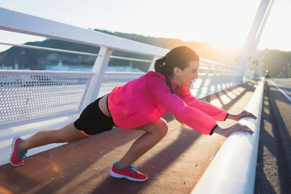 Sportswoman stretching muscles before start — ストック写真