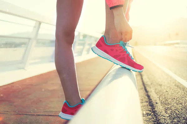 Woman tying the lace on her running shoes — Zdjęcie stockowe