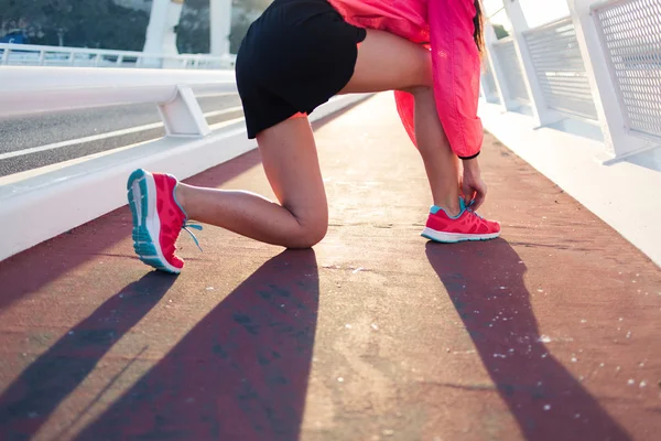 Woman tying the lace on running shoes — ストック写真