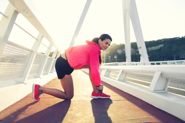 Mujer atando el encaje en zapatillas de running —  Fotos de Stock