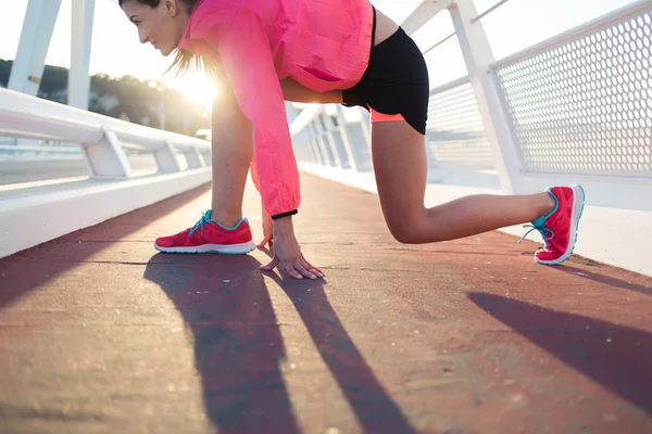 Sportswoman stretching muscles before start — Stok fotoğraf