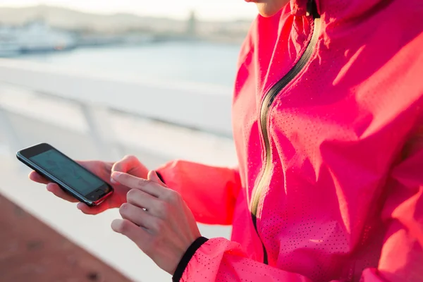 Sportswoman hands using mobile phone — Stock Photo, Image