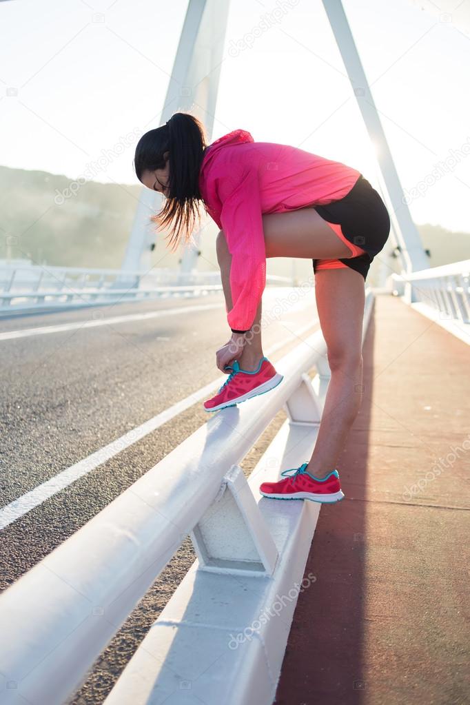 Woman tying the lace on her running shoes