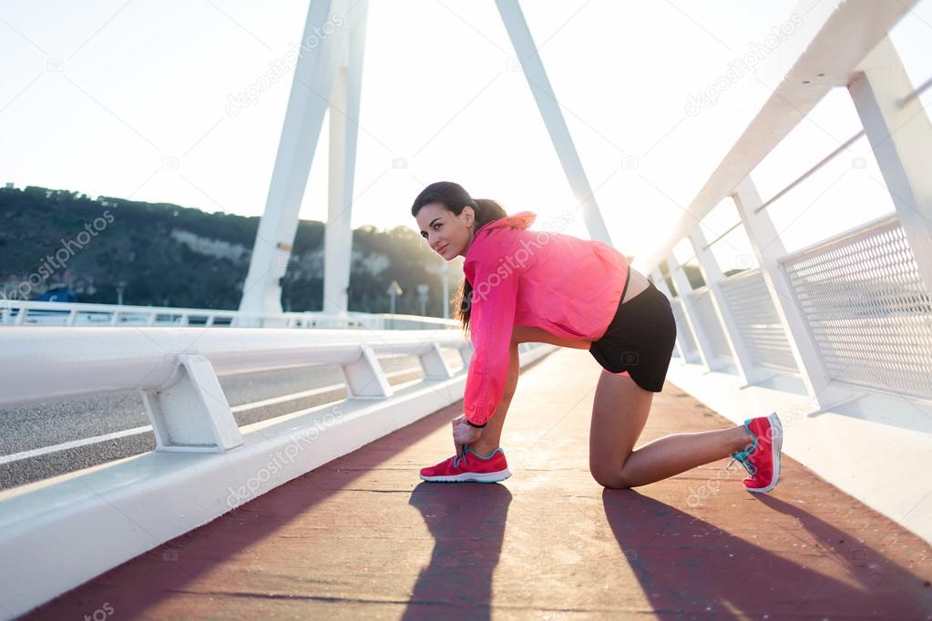 Woman tying the lace on running shoes