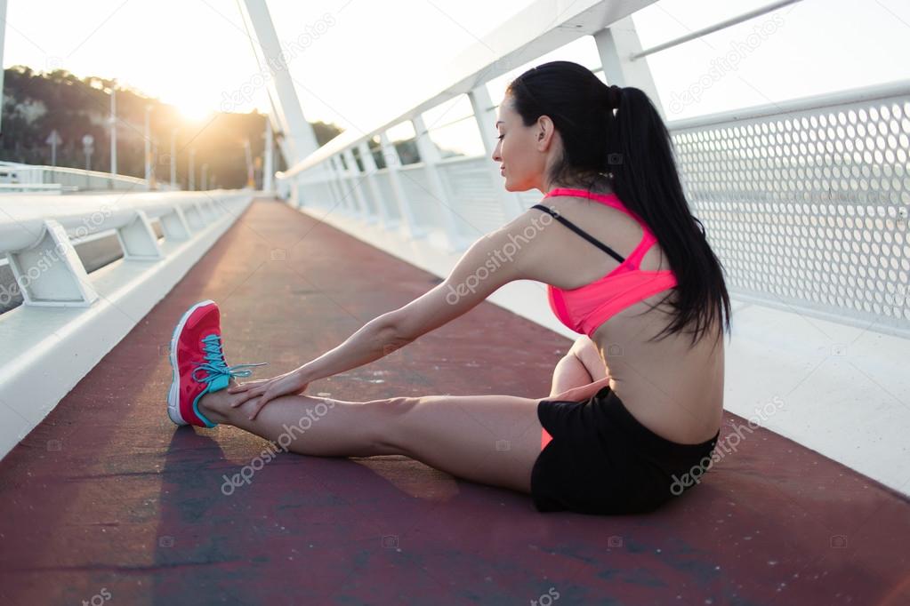 Fitness woman runner stretching legs muscles