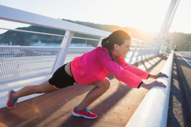 Sportswoman stretching muscles before start